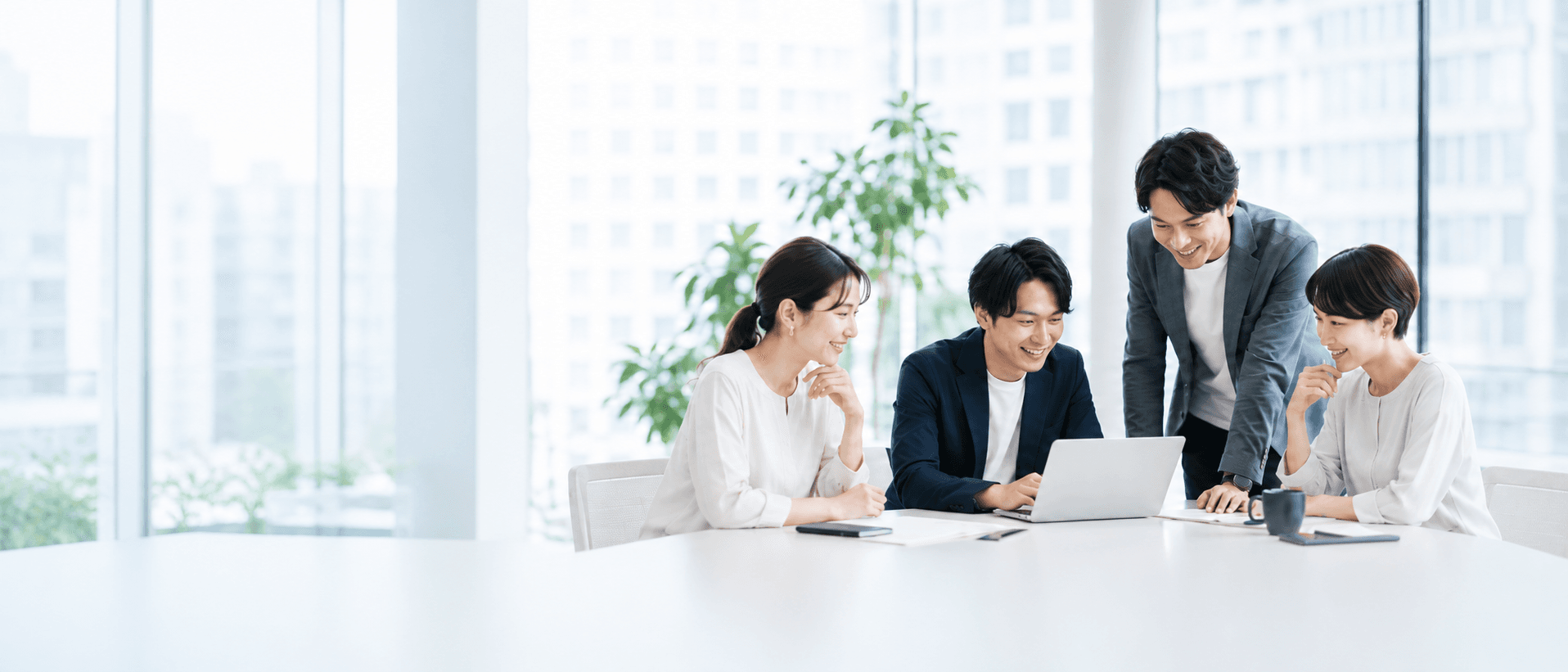 オフィスでノートパソコンを囲みながら打ち合わせをするPochifyのメンバー